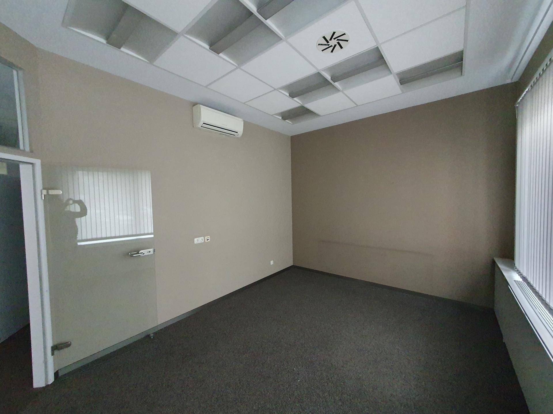Ruhiger Büroraum mit Teppichboden, Klimaanlage und abgehängter Decke.