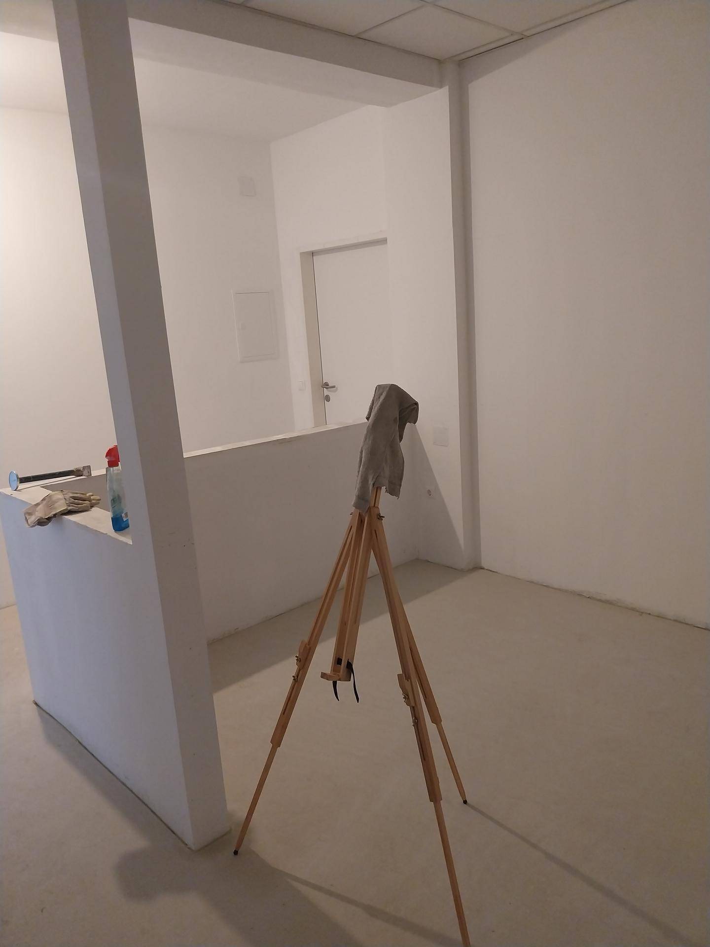 Raum im Bau mit einer halbhohen Trennwand und einer abgehängten Decke.