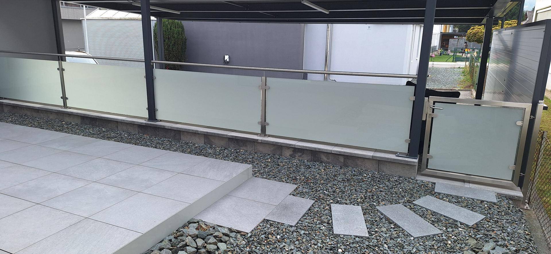 Geräumige Terrasse mit modernem Fliesenbelag und direktem Zugang zum Gartenbereich über einen Kiesweg.