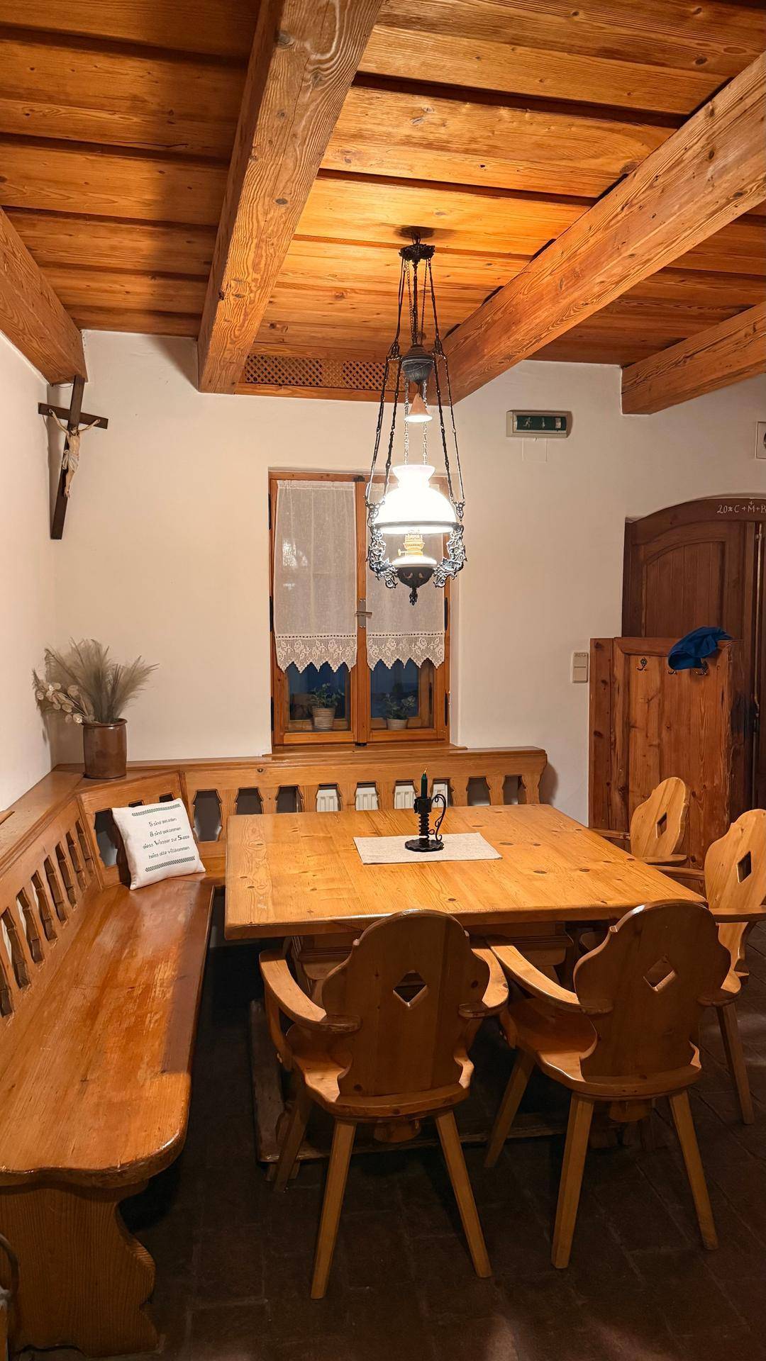 Gemütlicher Essbereich mit Holzbalkendecke, rustikalen Holzmöbeln und traditioneller Beleuchtung.