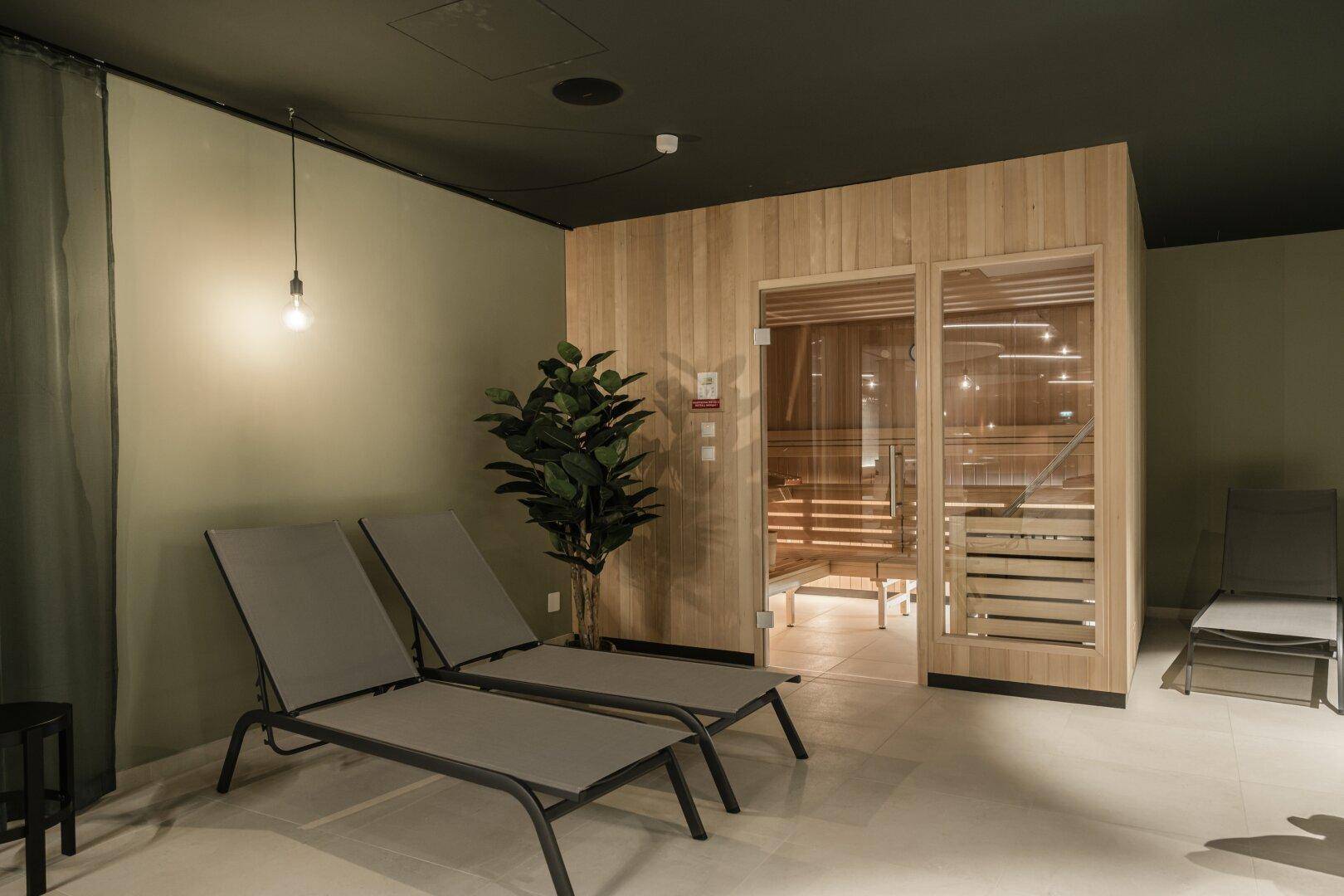 Entspannungsbereich mit Sauna und Liegestühlen, ideal für Wellness und Erholung.
