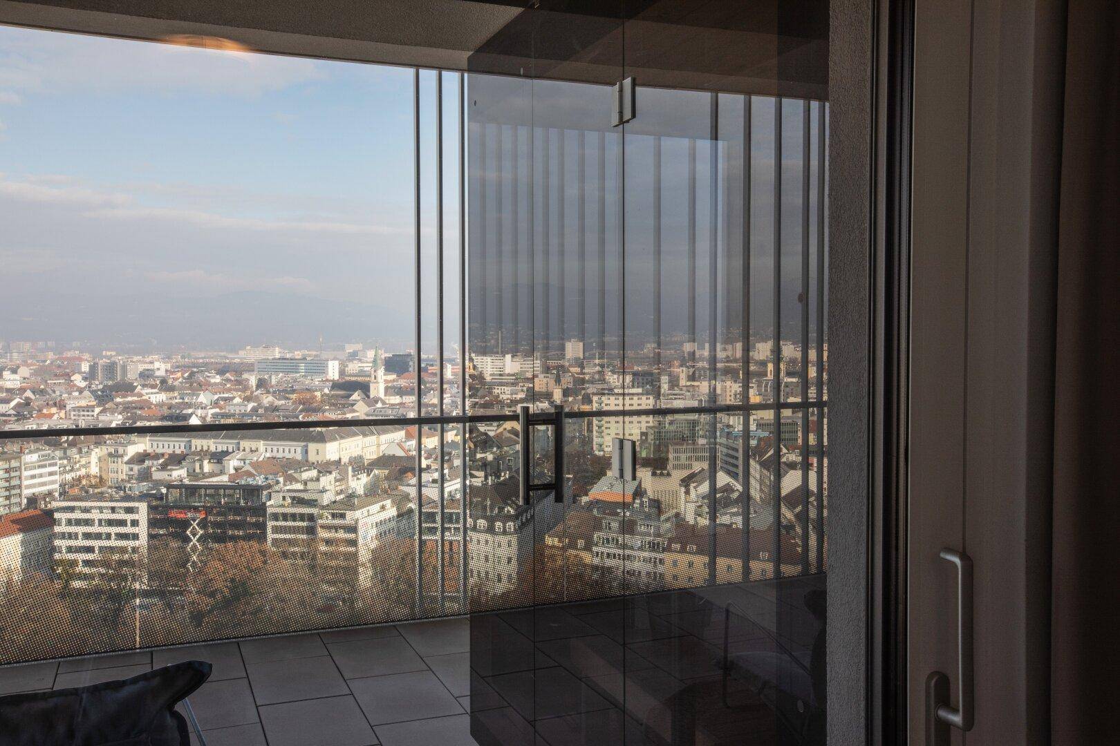 Balkon mit Glasbrüstung und beeindruckendem Panoramablick über die städtische Landschaft.