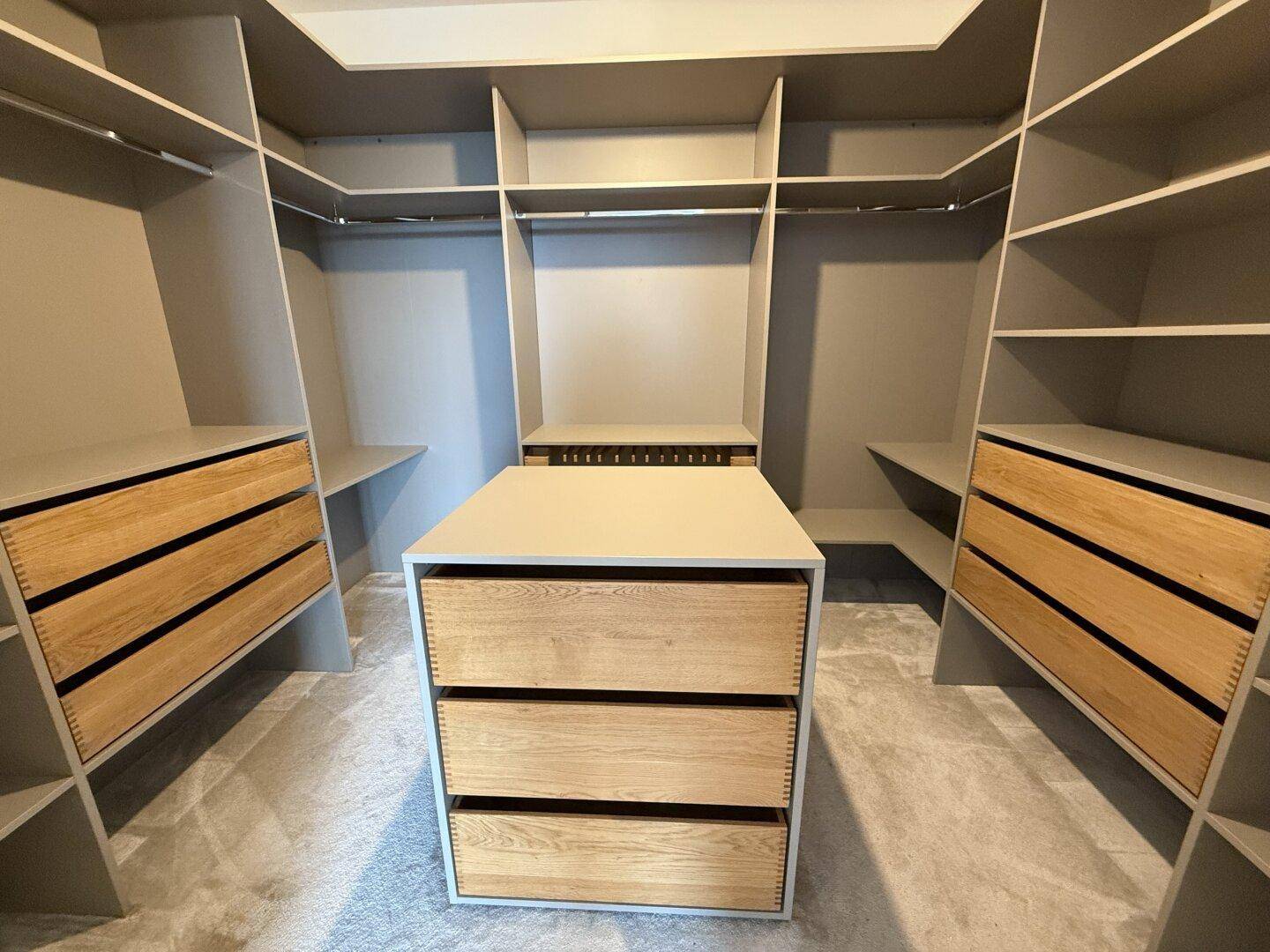 Geräumiger begehbarer Kleiderschrank mit maßgefertigten Regalen und Schubladen.