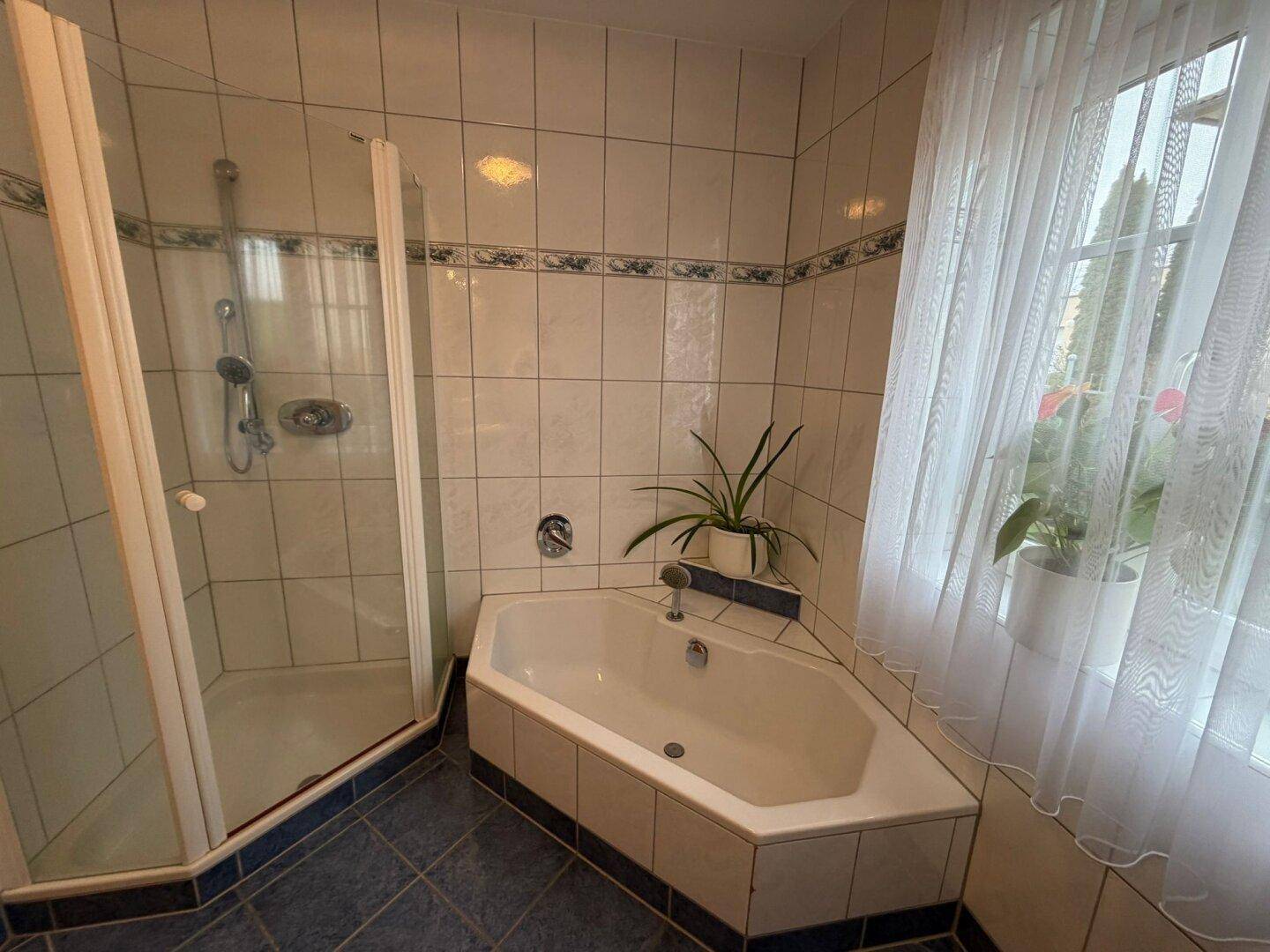 Badezimmer mit Eckbadewanne, Duschkabine und hellen Fliesen.