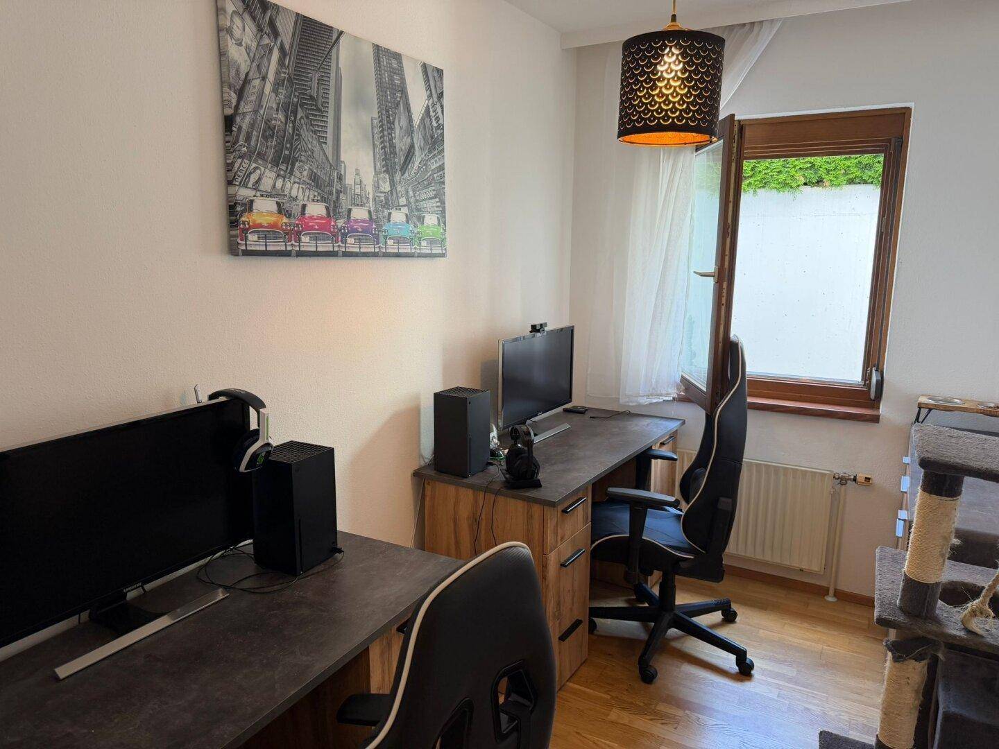 Arbeitszimmer mit zwei Schreibtischen, Computern und Fenster.