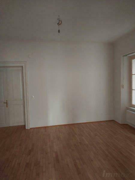 Geräumiges Zimmer mit hellem Dielenboden und einem Fenster, bietet Potenzial für individuelle Gestaltung.