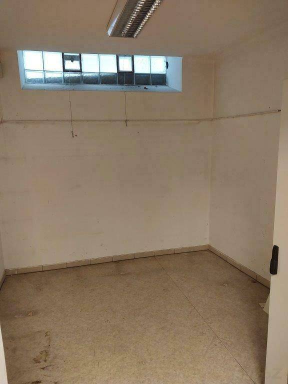 Kleiner Lagerraum mit Fliesenboden und einem schmalen Fensterband nahe der Decke.