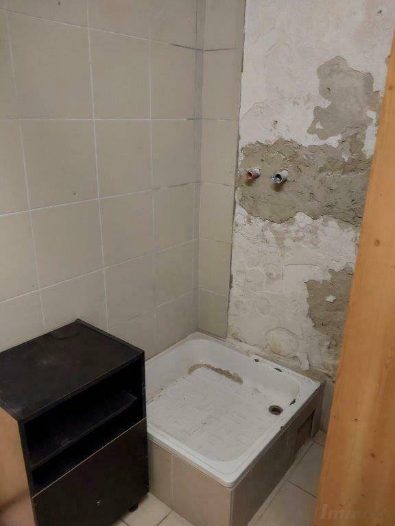 Kellerbadezimmer im Rohbau mit Duschwanne und vorbereiteten Anschlüssen.
