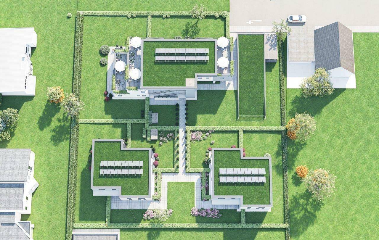Draufsicht auf die moderne Wohnanlage mit begrünten Dächern, Terrassen und weitläufigen Grünflächen.