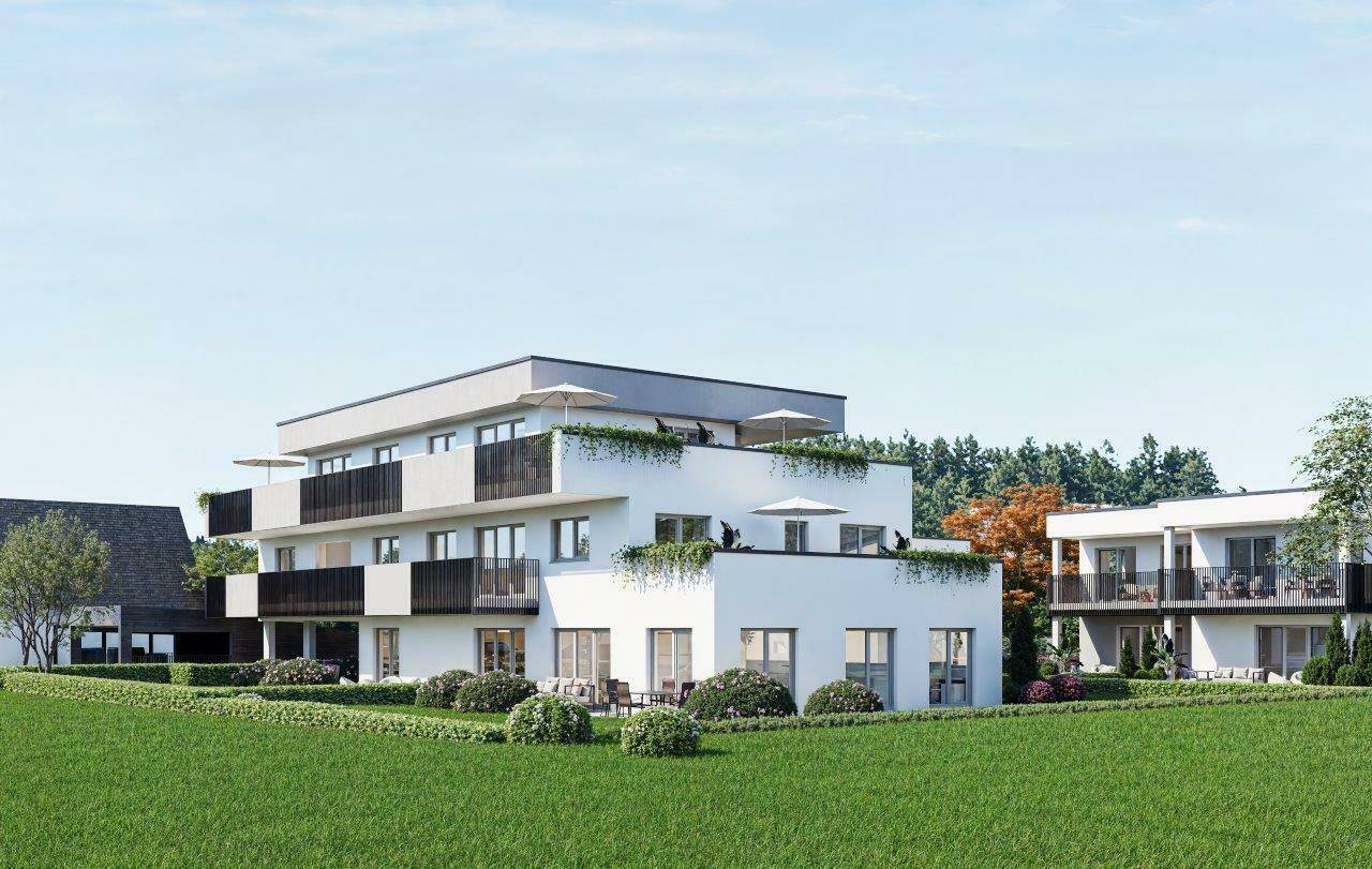 Moderne Wohnanlage mit weißer Fassade, Balkonen und begrünten Terrassen in sonniger Umgebung.