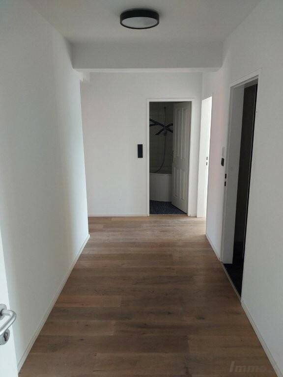 Heller Flur mit Parkettboden und Zugang zu verschiedenen Räumen.