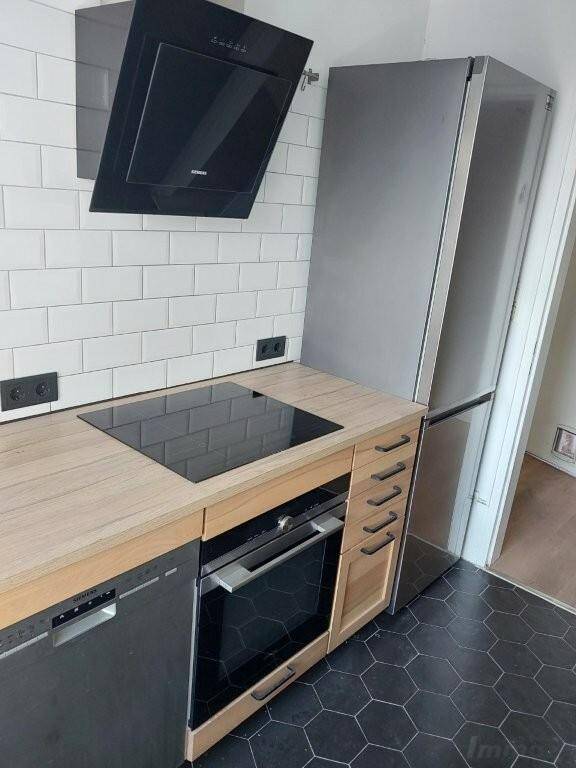 Moderne Küche mit Induktionskochfeld, Backofen, Geschirrspüler und Kühlschrank.