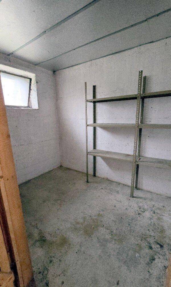 Kellerraum mit Betonboden und einem kleinen Fenster, ideal als Lagerfläche.