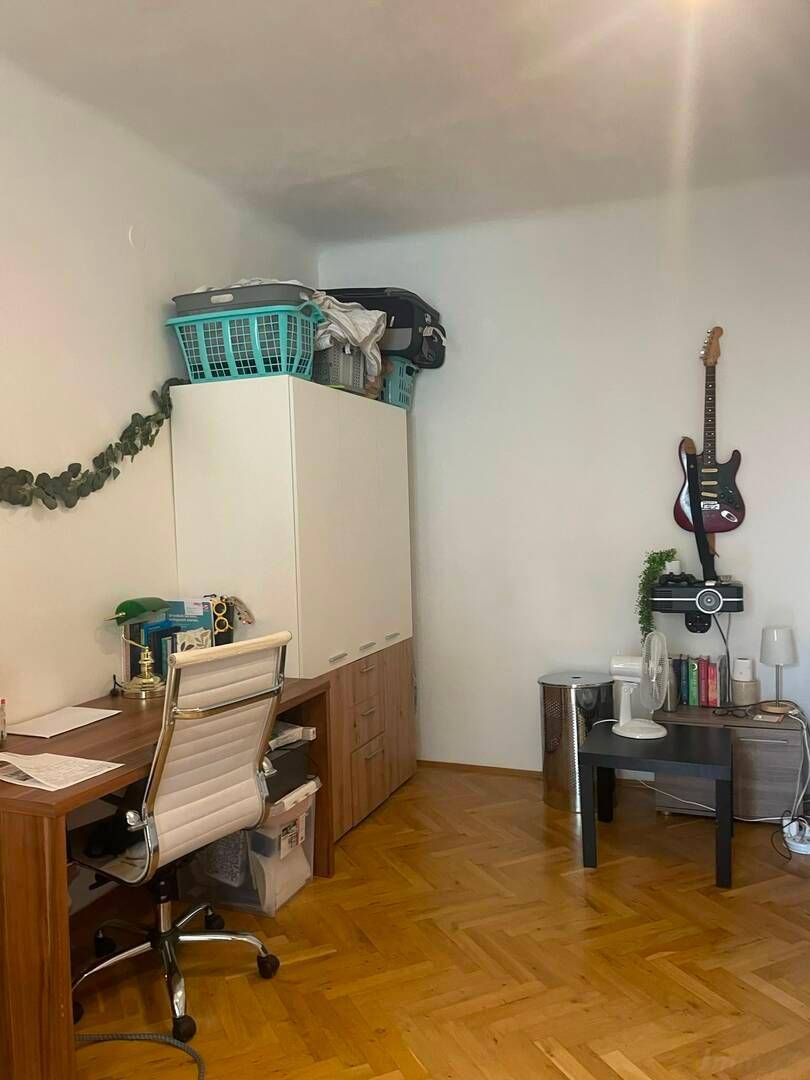 Arbeitsbereich mit Holzschreibtisch, Bürostuhl und Stauraum.