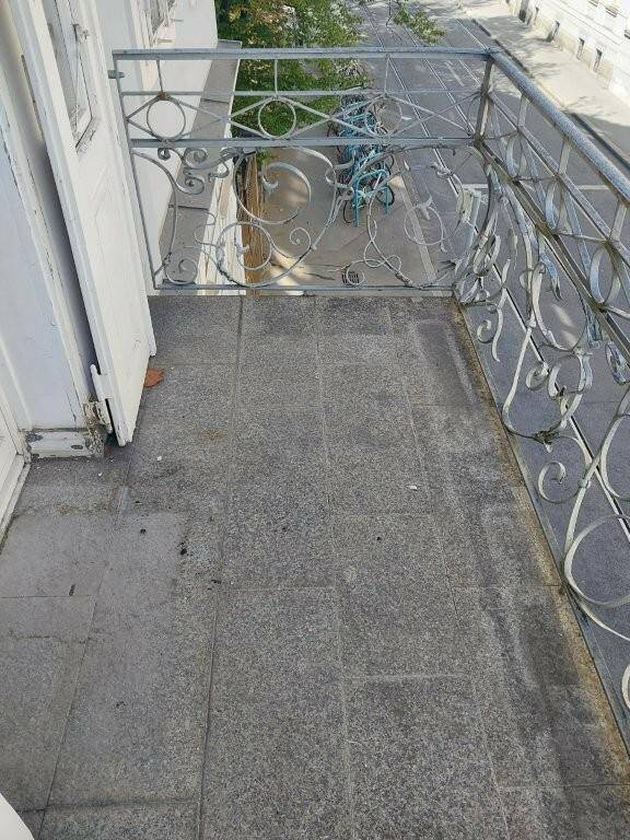 Kleiner Balkon mit schmiedeeisernem Geländer und Blick auf die Straße.