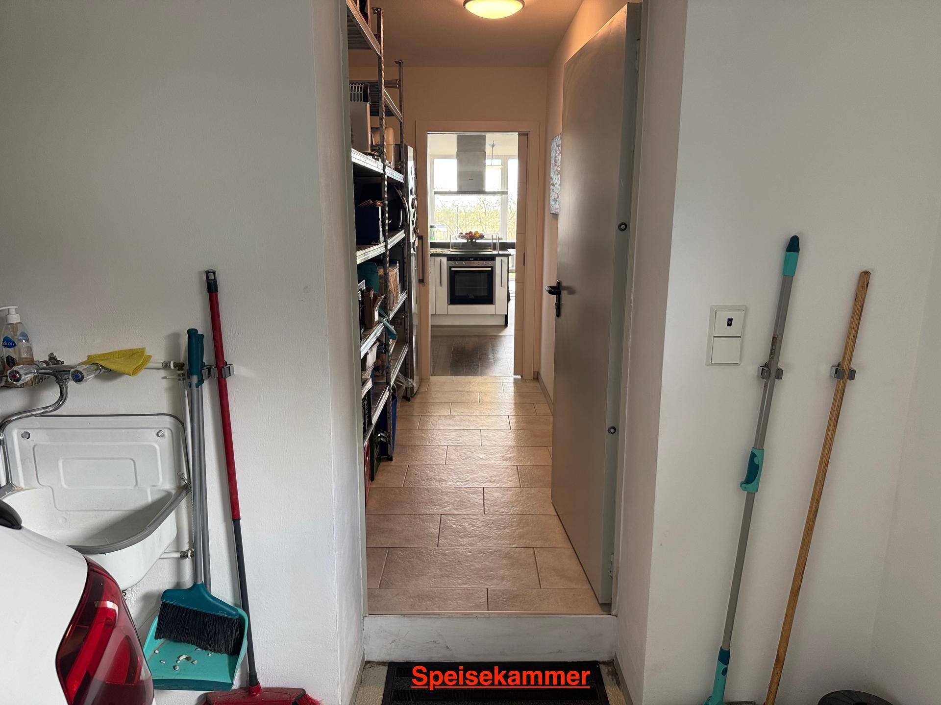 Geräumige Speisekammer mit Regalen und Blick in einen weiteren Raum.