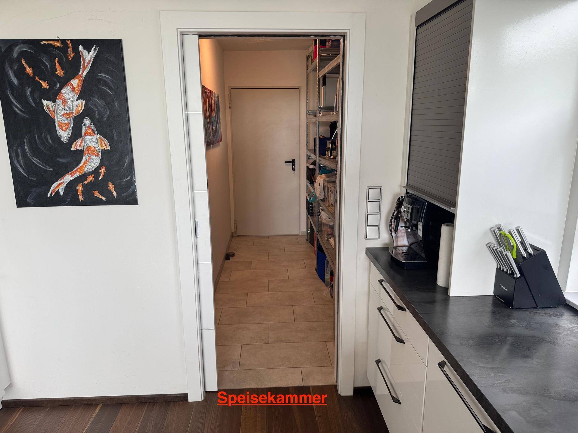Gut organisierte Speisekammer mit Regalen und direktem Zugang zur Küche.