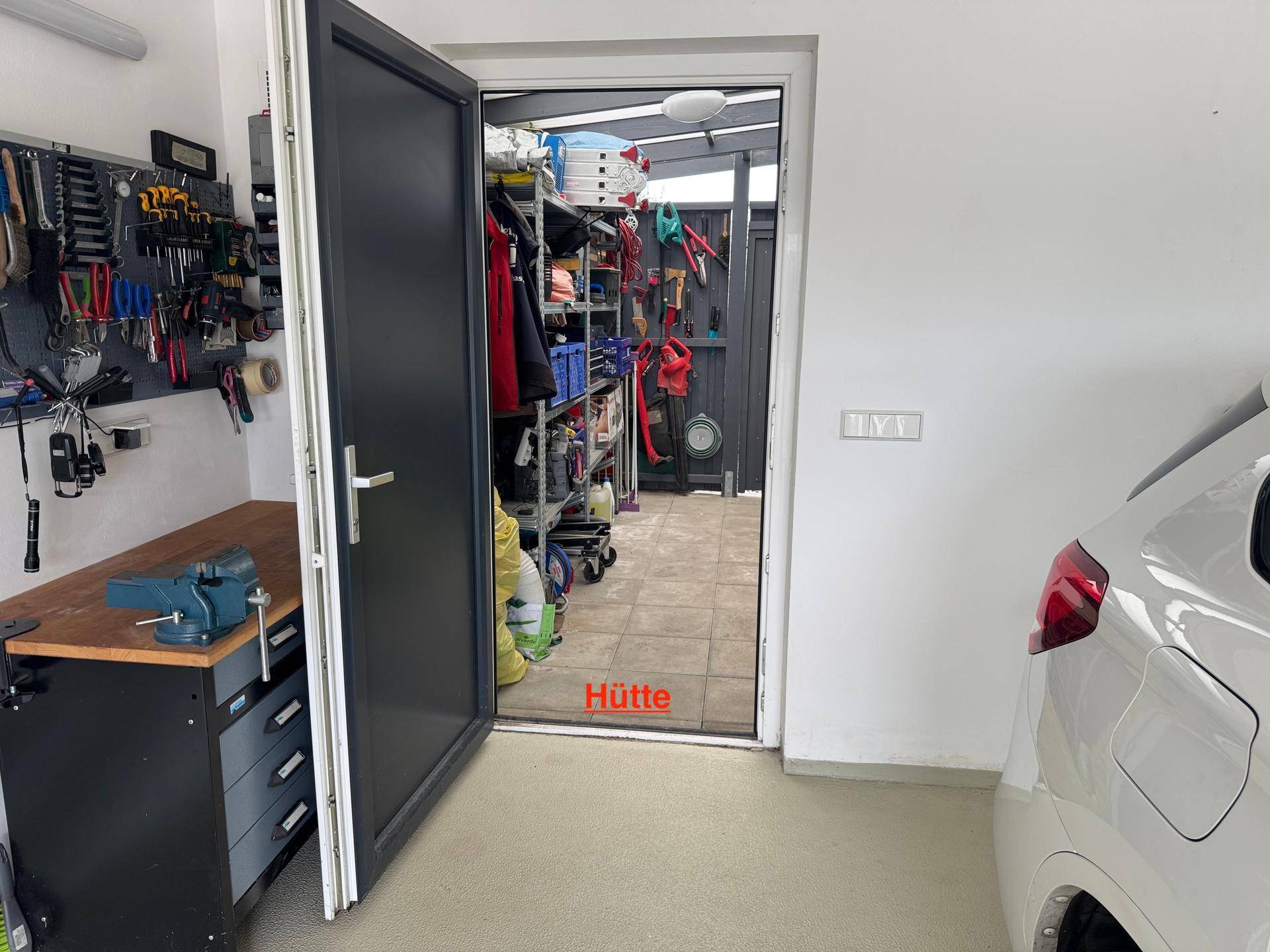 Praktische Hütte mit Regalen für Werkzeuge und Gartengeräte.