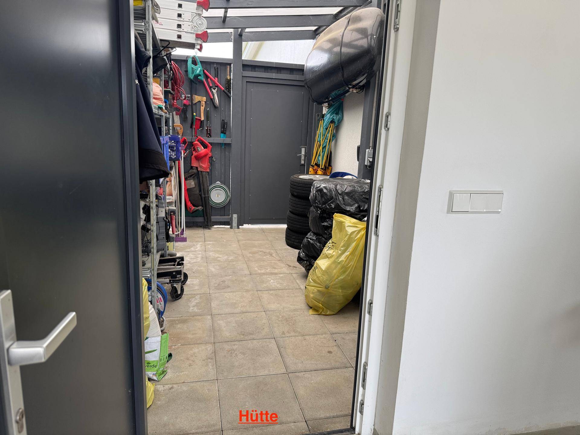 Gut organisierte Hütte mit Regalen, Werkzeugen und Reifenlagerung.