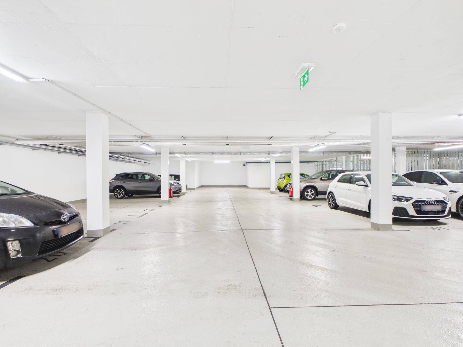 Geräumige Tiefgarage mit vielen Parkmöglichkeiten und klarer Beschilderung für die Stellplätze.