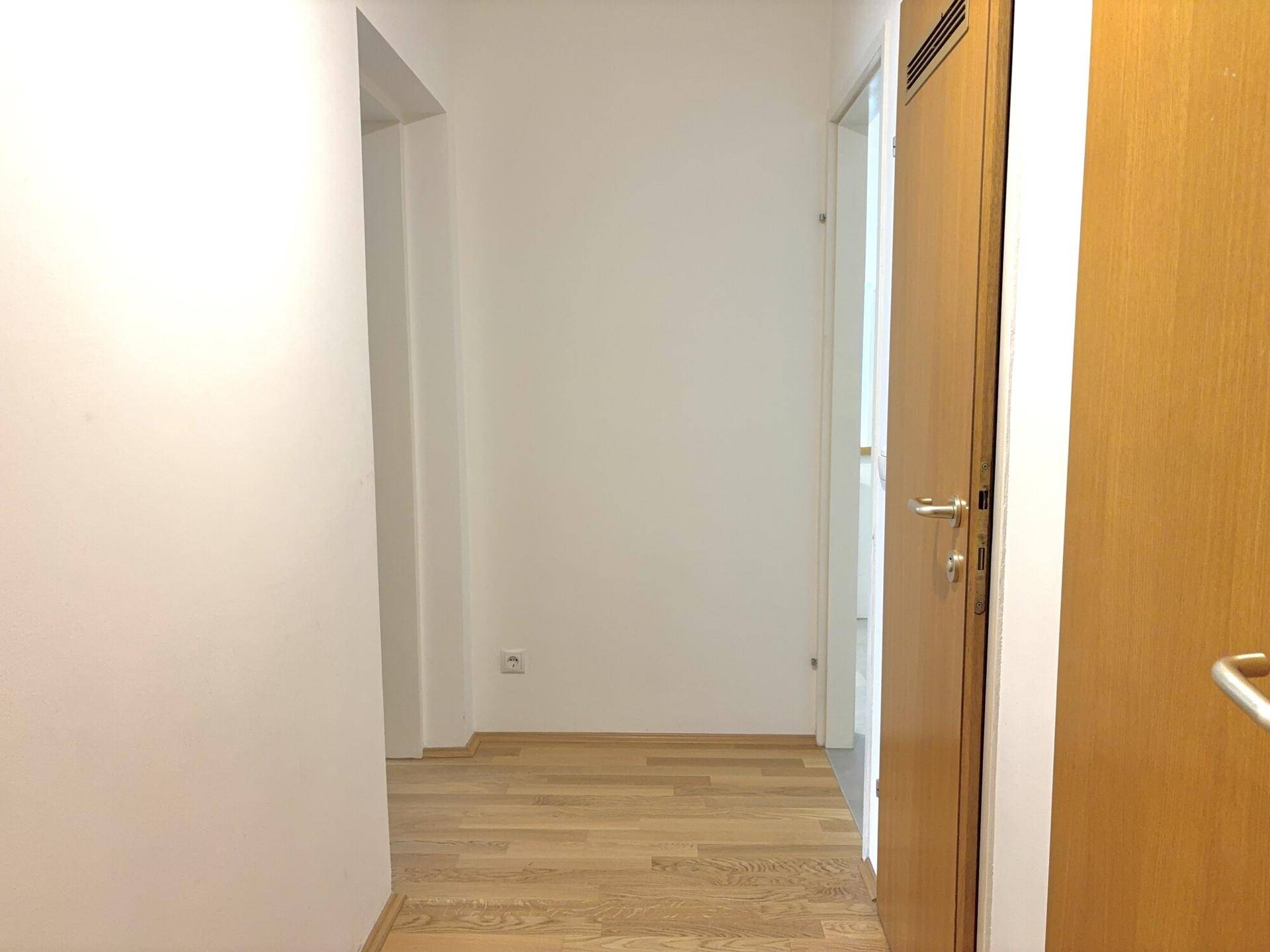 Heller Flur mit Holzboden und modernen Holztüren, der zu den verschiedenen Zimmern führt.