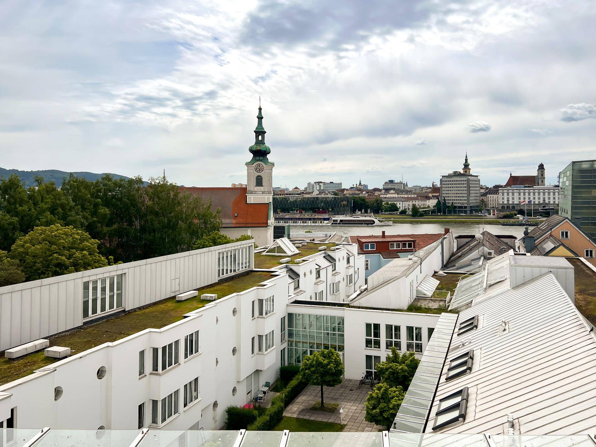 Panoramablick über die Stadt mit Fluss, historischen Gebäuden und moderner Architektur.
