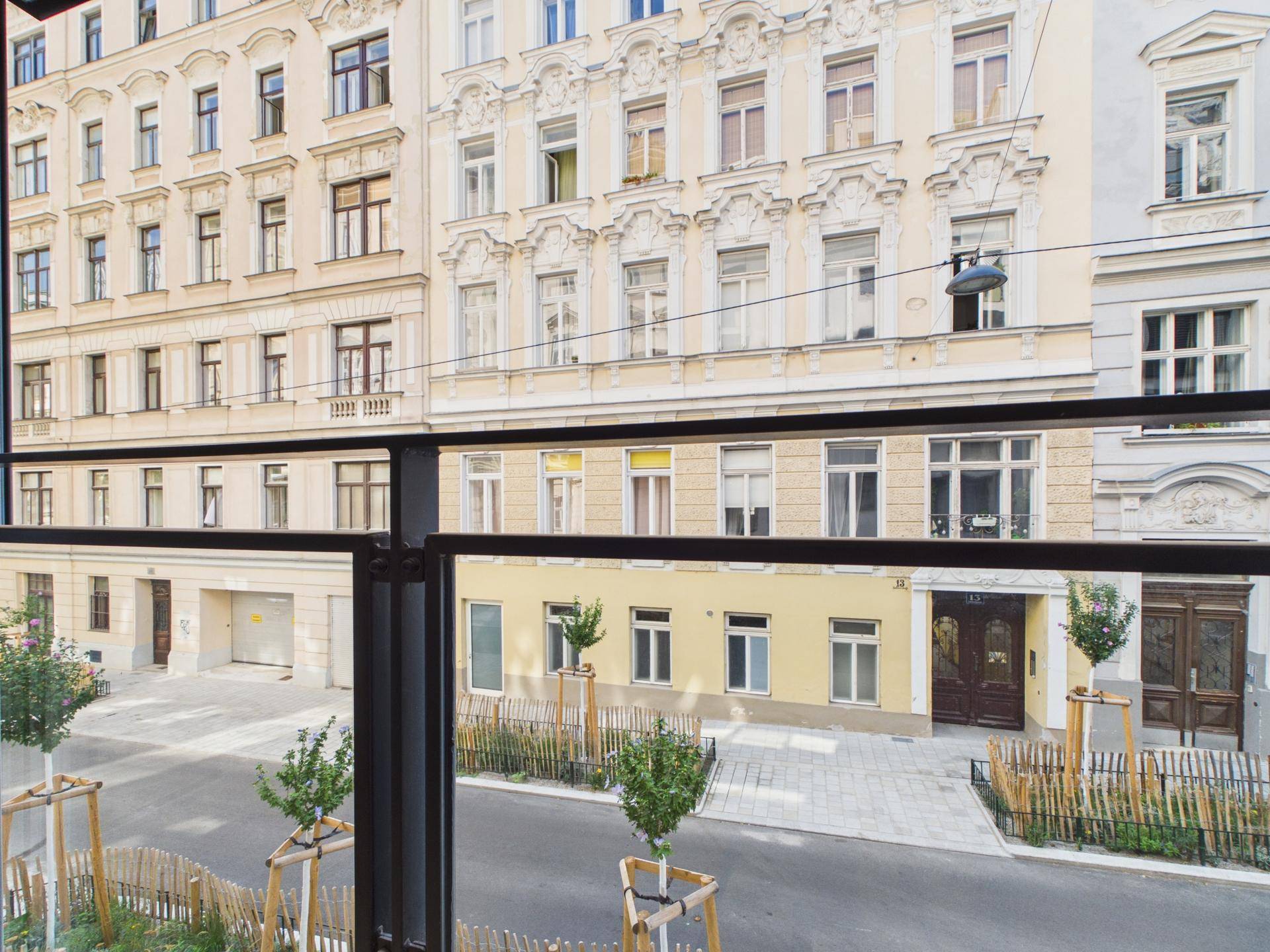 Blick von einem Balkon auf die belebte Straße und die historische Architektur der Nachbargebäude.