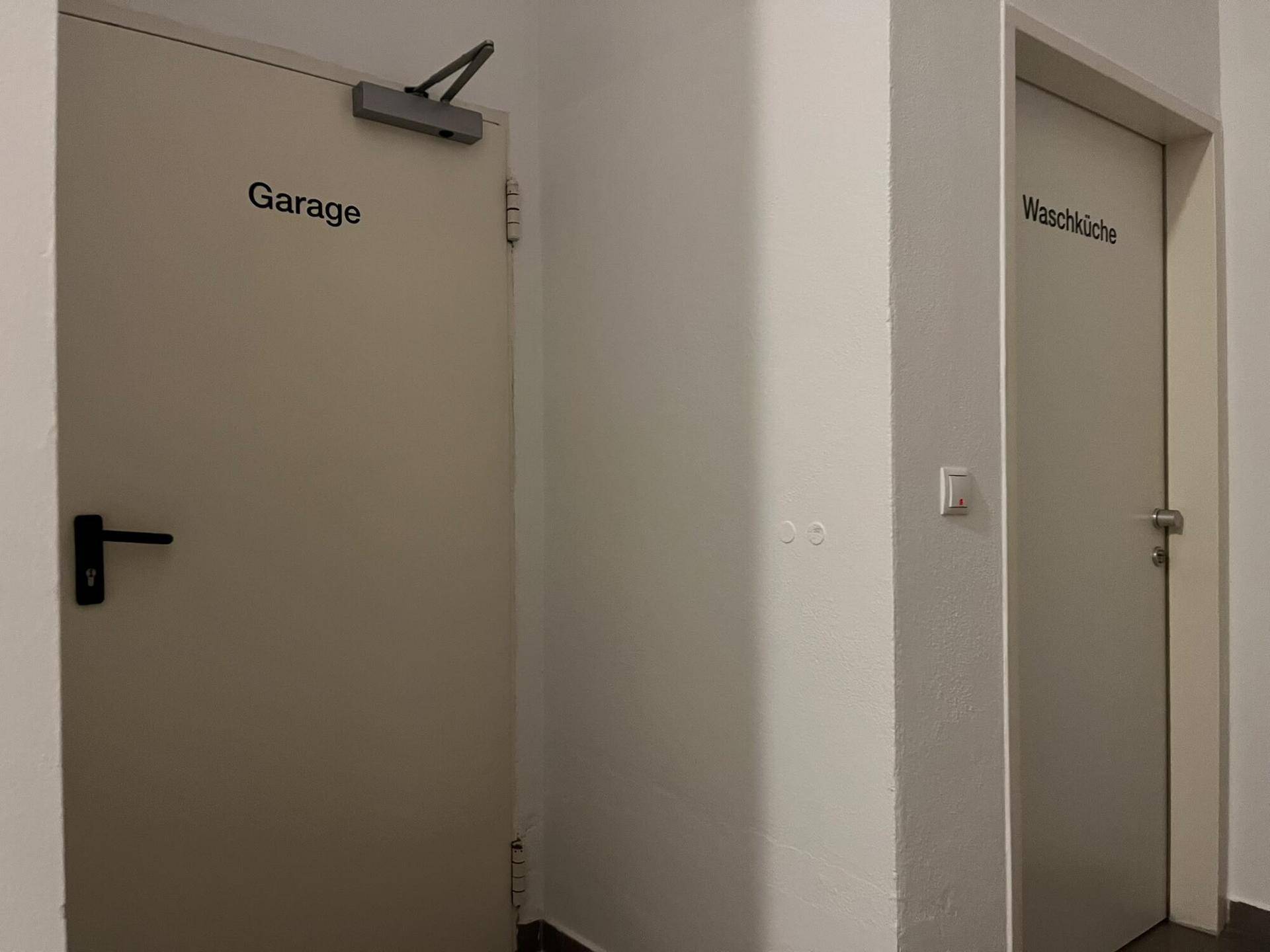 Flur mit Türen zu den Gemeinschaftsräumen wie Garage und Waschküche.