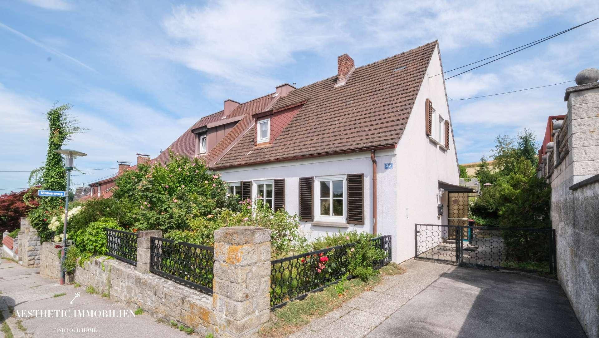 Charmantes Einfamilienhaus mit Satteldach, Fensterläden und gepflegtem Vorgarten.