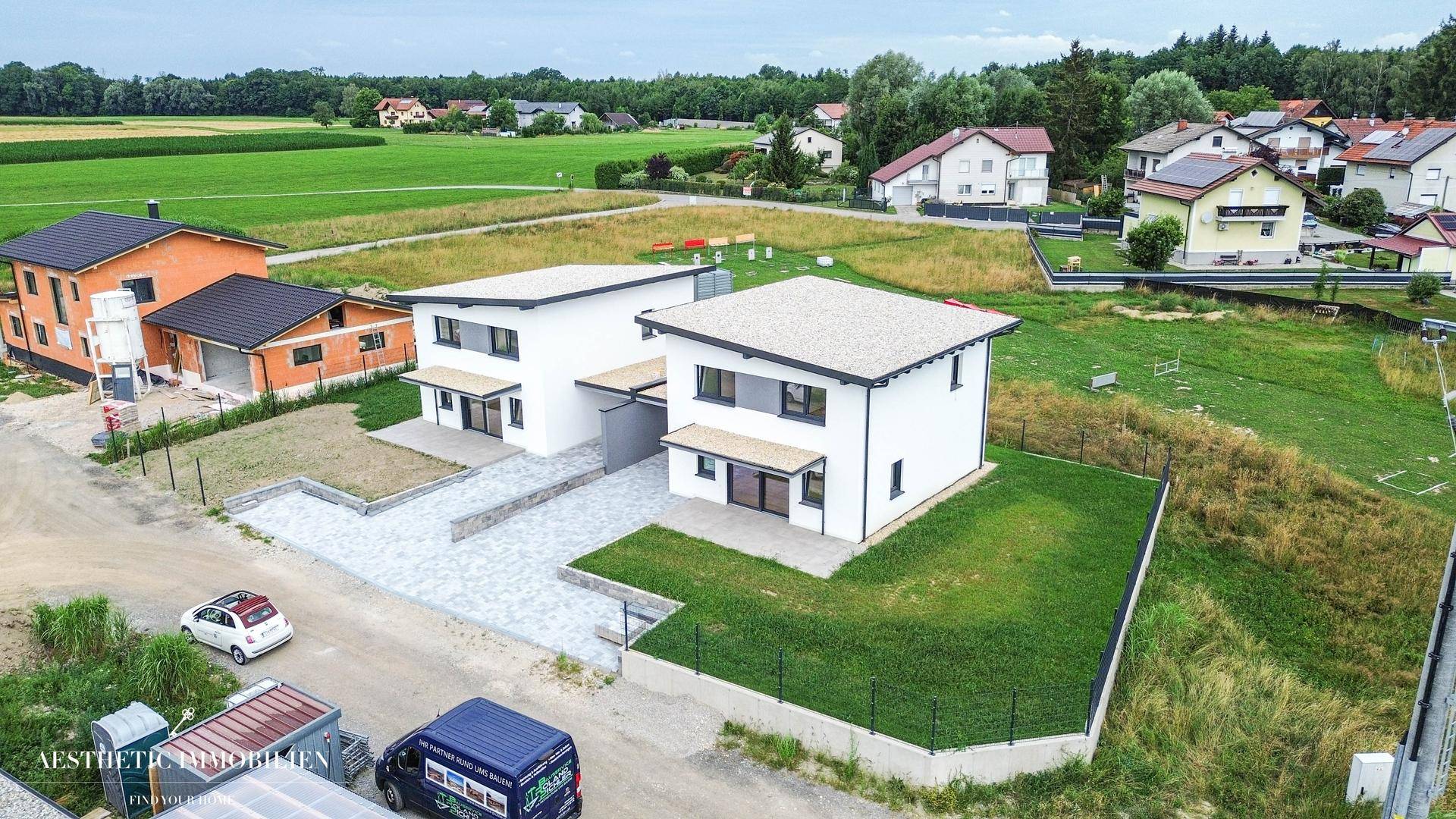 Weitläufige Luftaufnahme des Neubaus in einer ruhigen Wohngegend mit viel Grün.