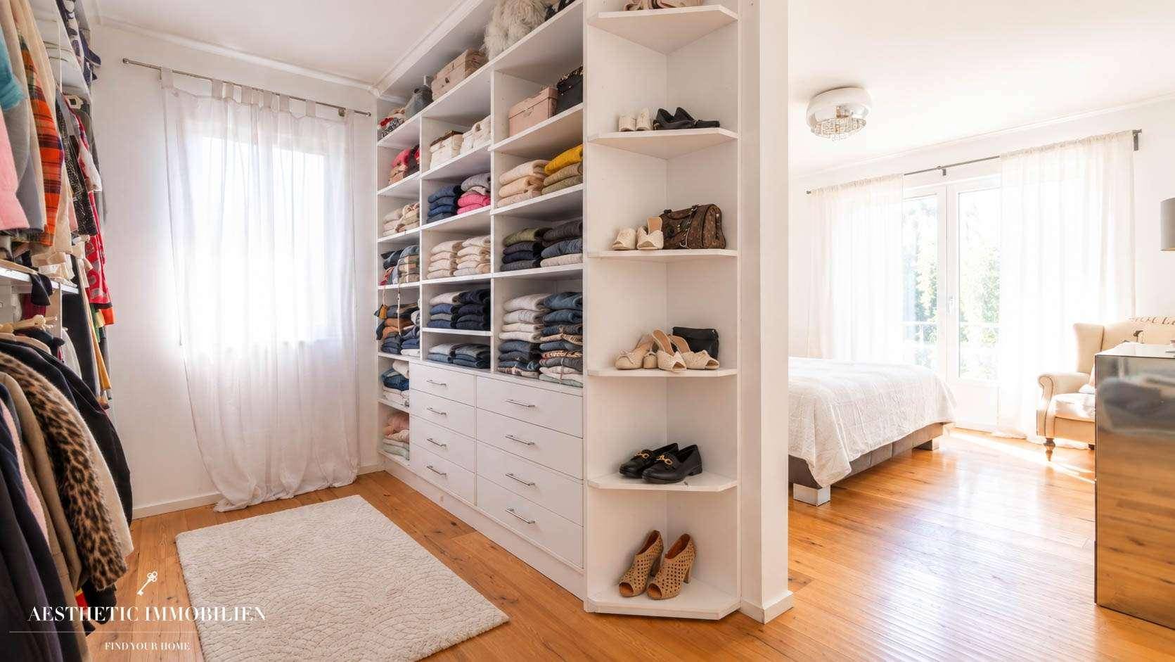 Begehbarer Kleiderschrank mit viel Stauraum und Verbindung zum Schlafzimmer.