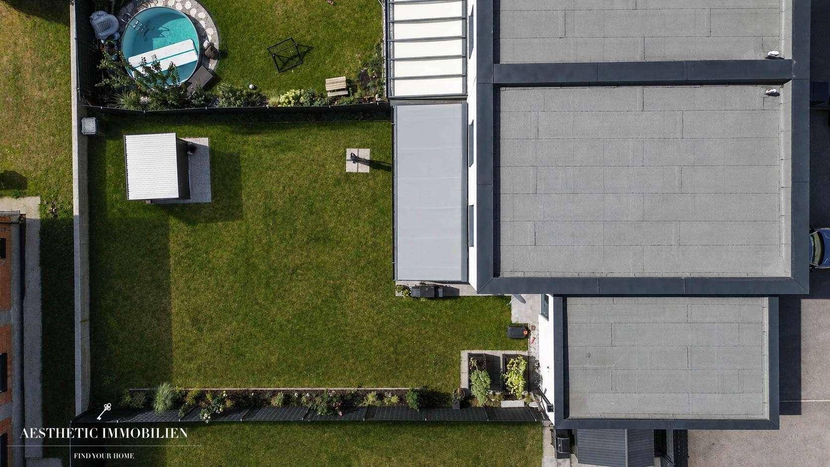 Vogelperspektive des Hauses mit Garten, Terrasse und angrenzendem Nachbargrundstück.