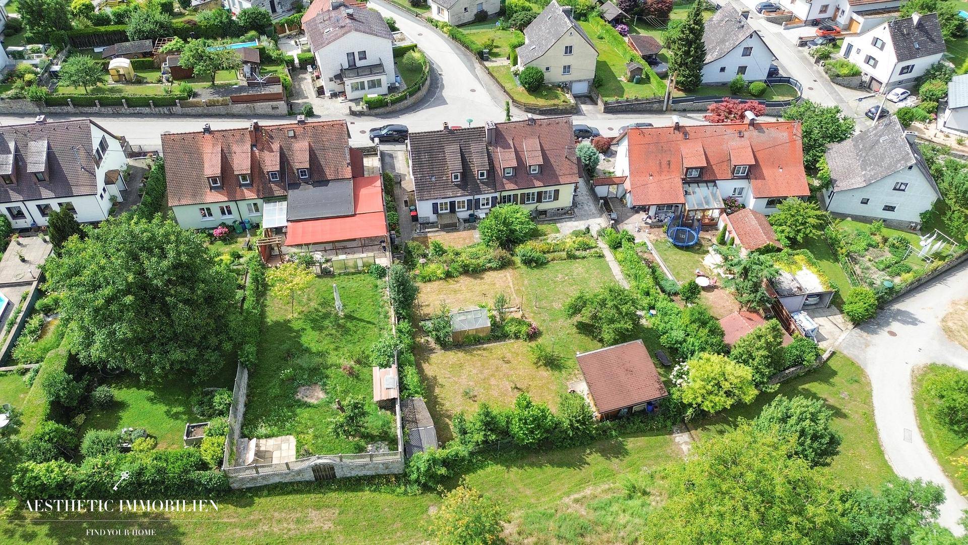 Weitläufige Luftaufnahme der Wohnsiedlung mit vielen Gärten und Häusern.