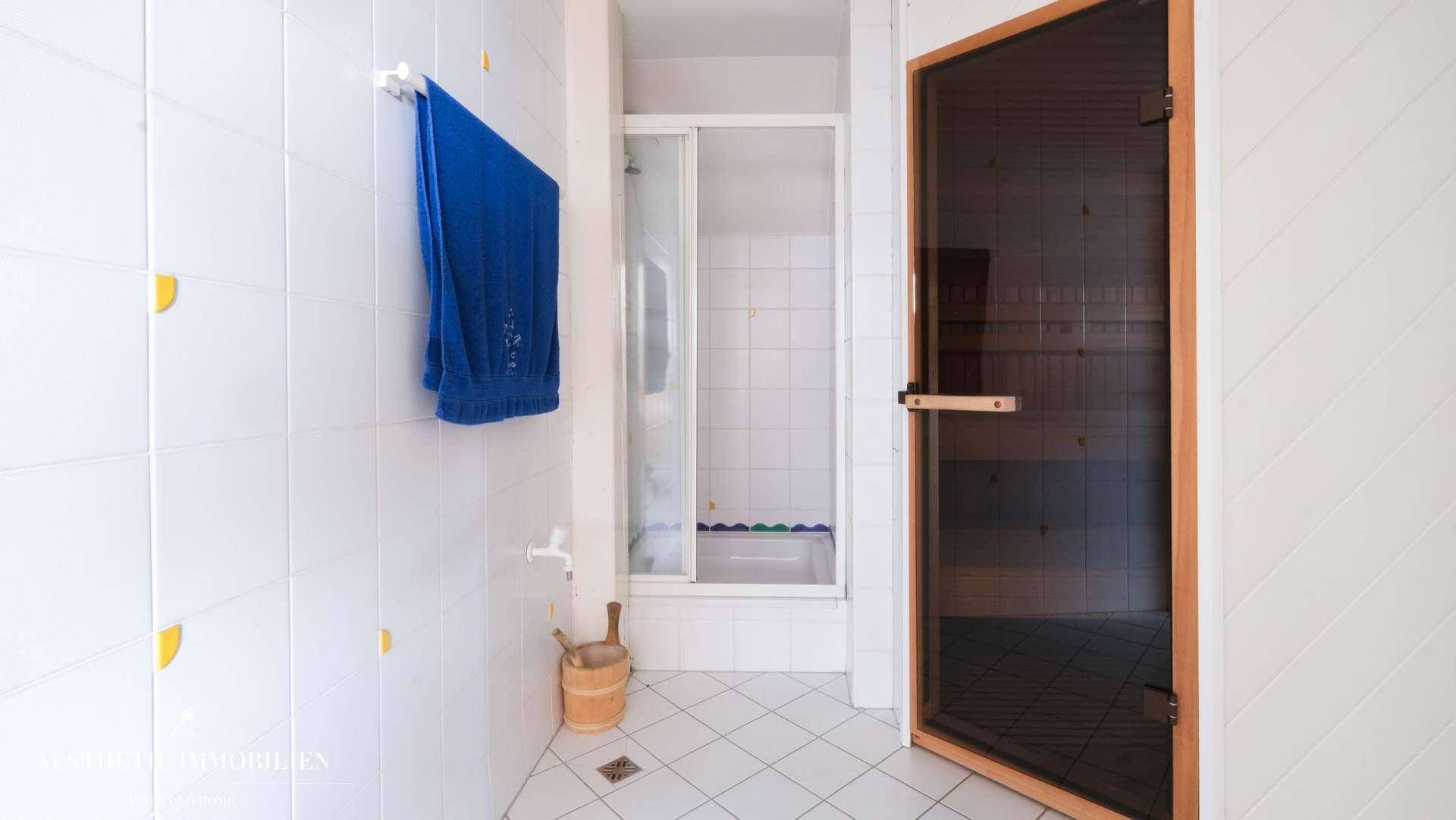 Badezimmer mit Duschkabine und integrierter Sauna für Wellnessmomente.
