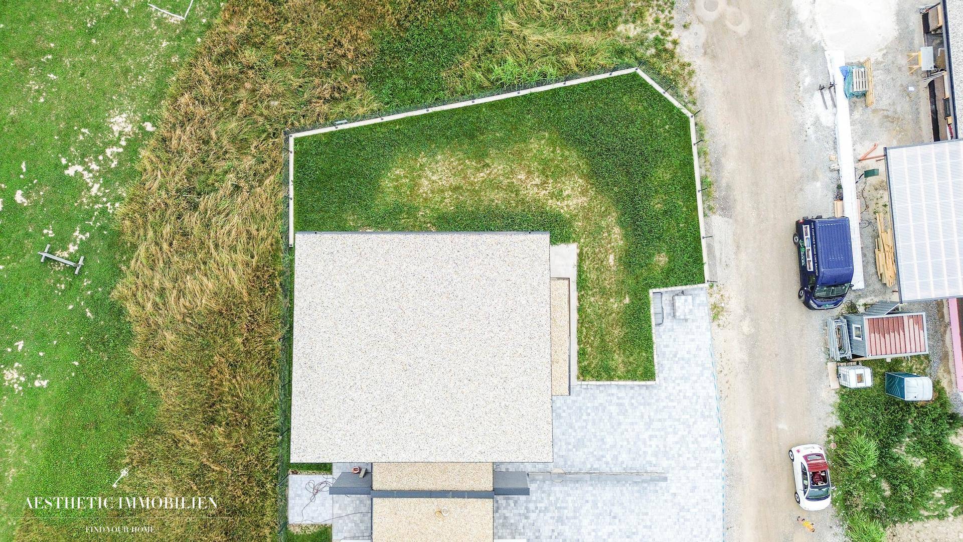 Vogelperspektive des Hauses mit gepflegtem Rasen und Zufahrtsbereich in ländlicher Umgebung.