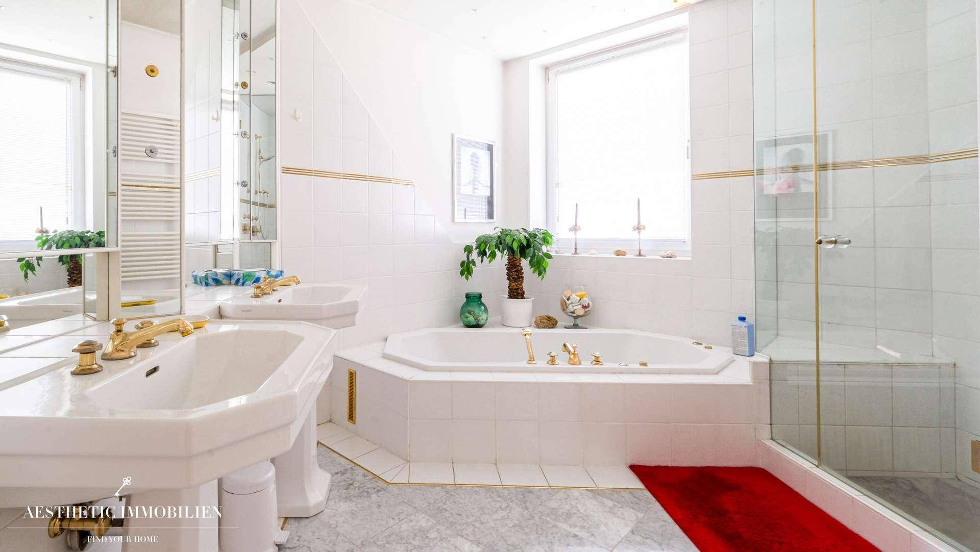 Helles Badezimmer mit Doppelwaschbecken, Eckbadewanne und separater Dusche.