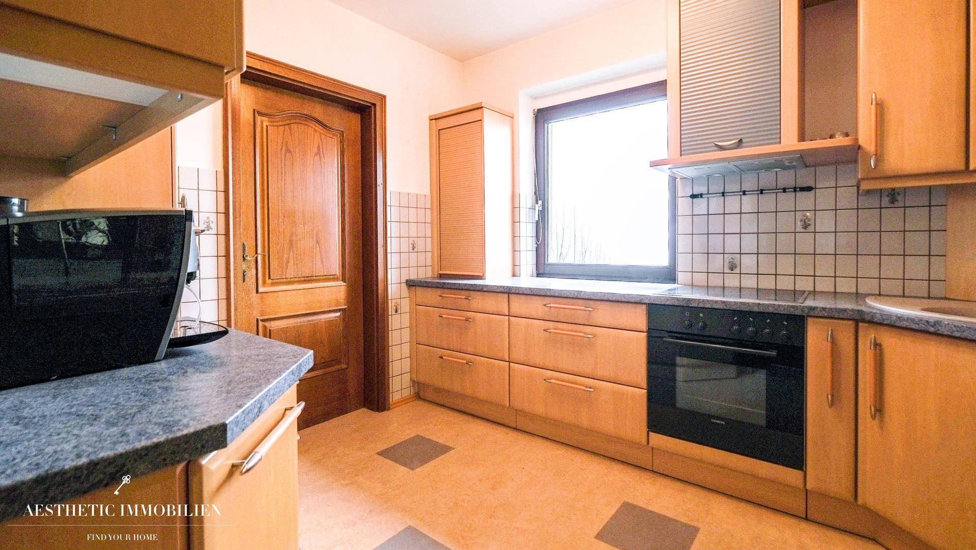 Küche im traditionellen Stil mit Holzschränken, Fliesen und Einbaugeräten.