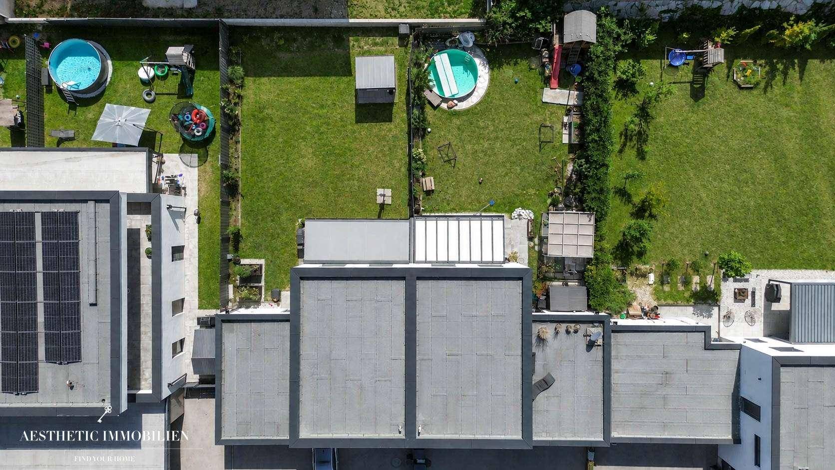 Luftaufnahme von mehreren modernen Häusern mit Gärten und Pools in der Nachbarschaft.