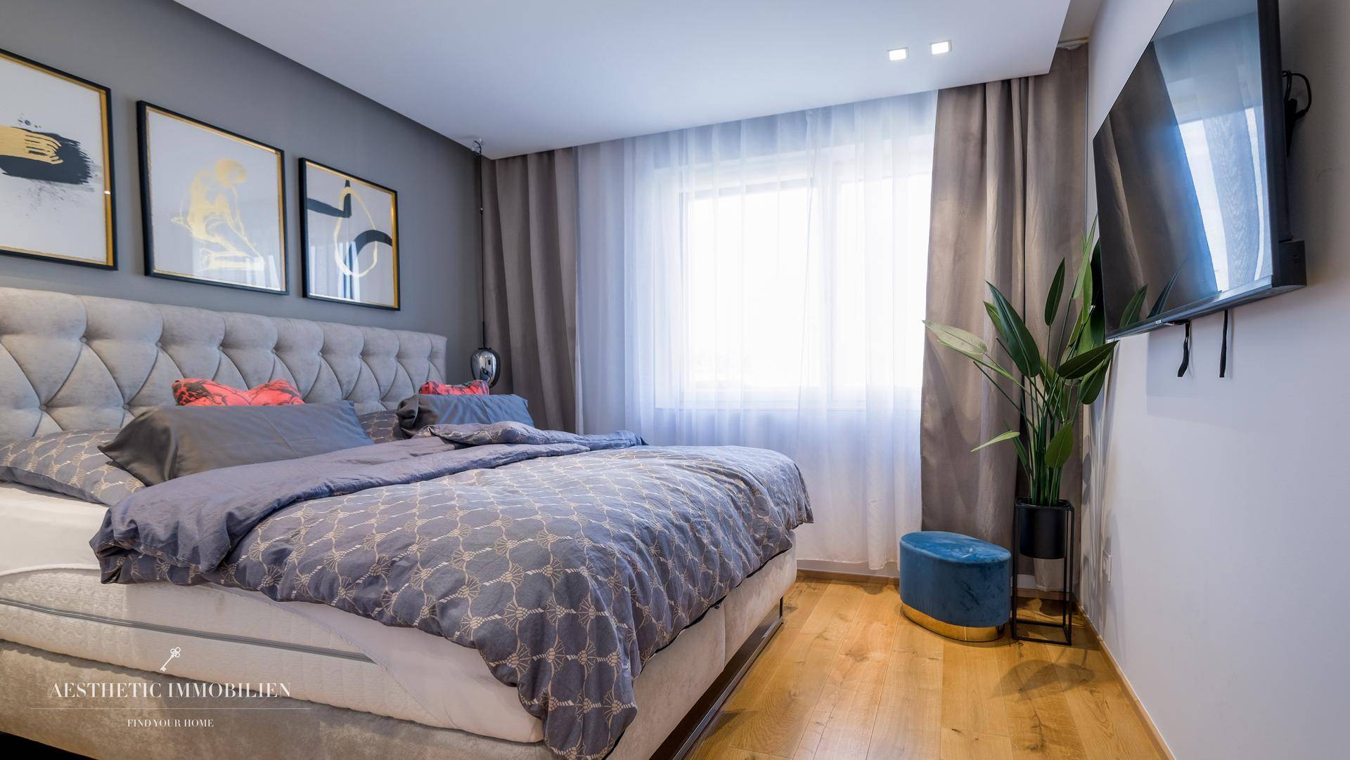 Gemütliches Schlafzimmer mit großem Bett, Holzboden und viel Tageslicht.