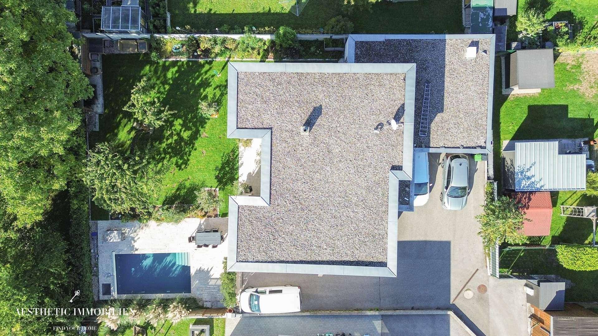 Vogelperspektive des Hauses mit Flachdach, Garten und Poolbereich.