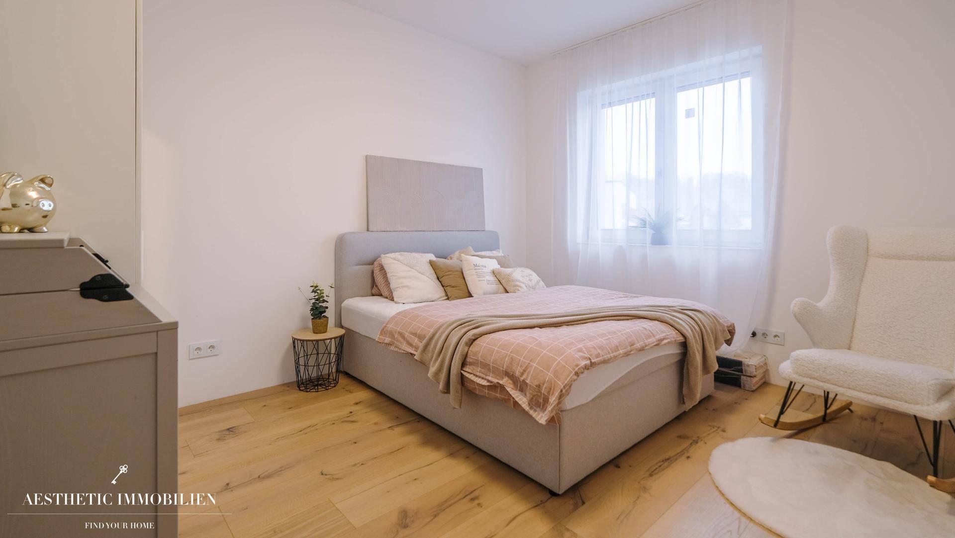 Gemütliches Schlafzimmer mit Holzboden, großem Bett und viel natürlichem Licht.