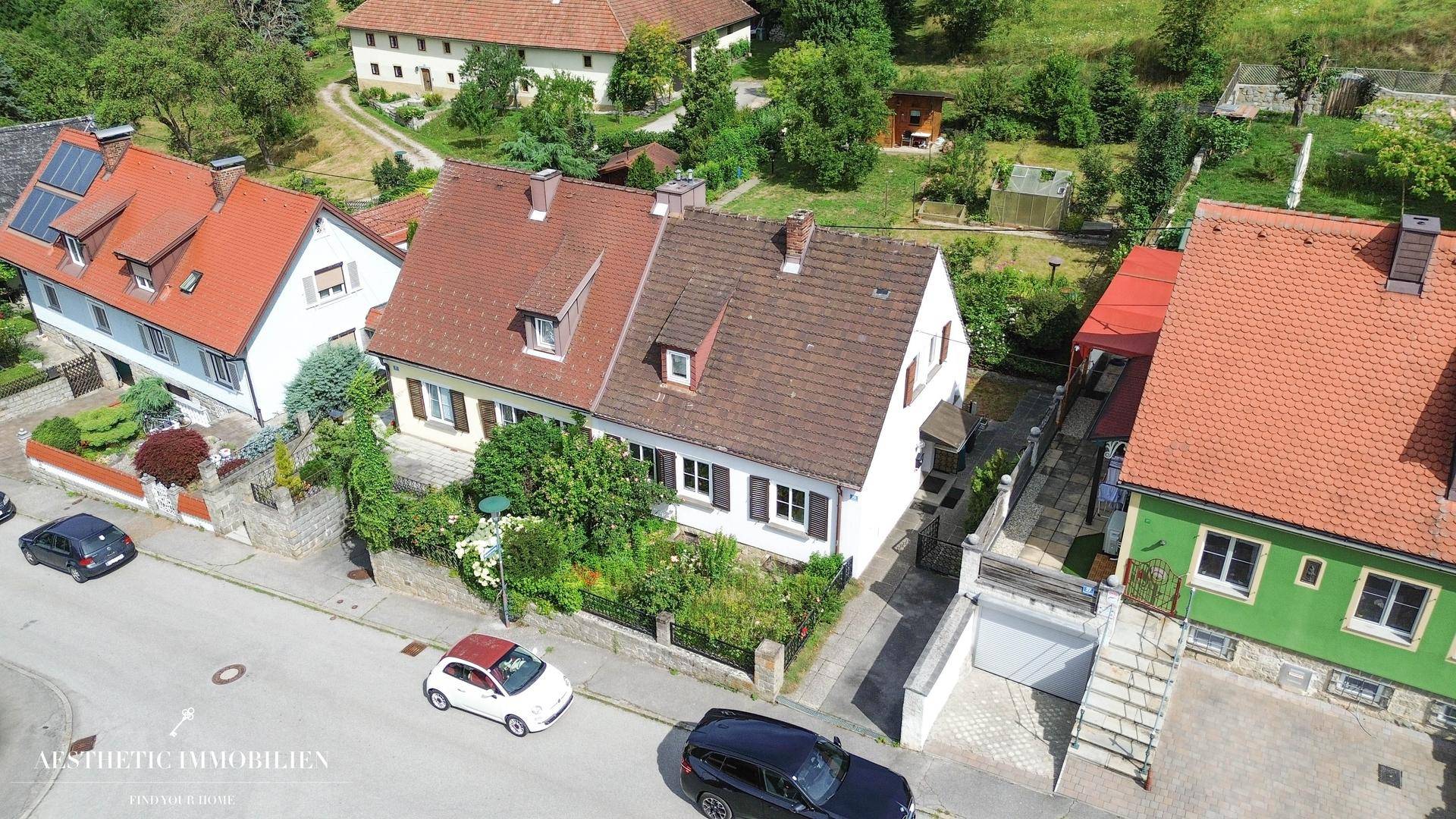 Luftaufnahme des Einfamilienhauses mit umliegenden Gärten und Nachbarschaft.