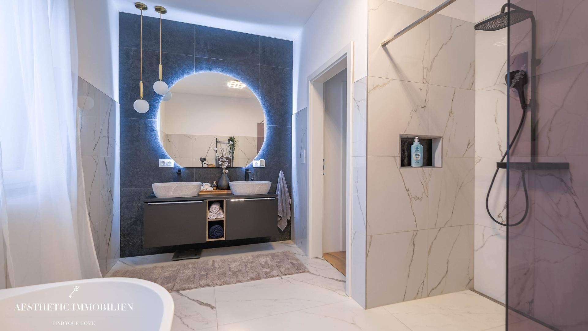 Elegantes Badezimmer mit Doppelwaschbecken, großer Dusche und freistehender Badewanne.