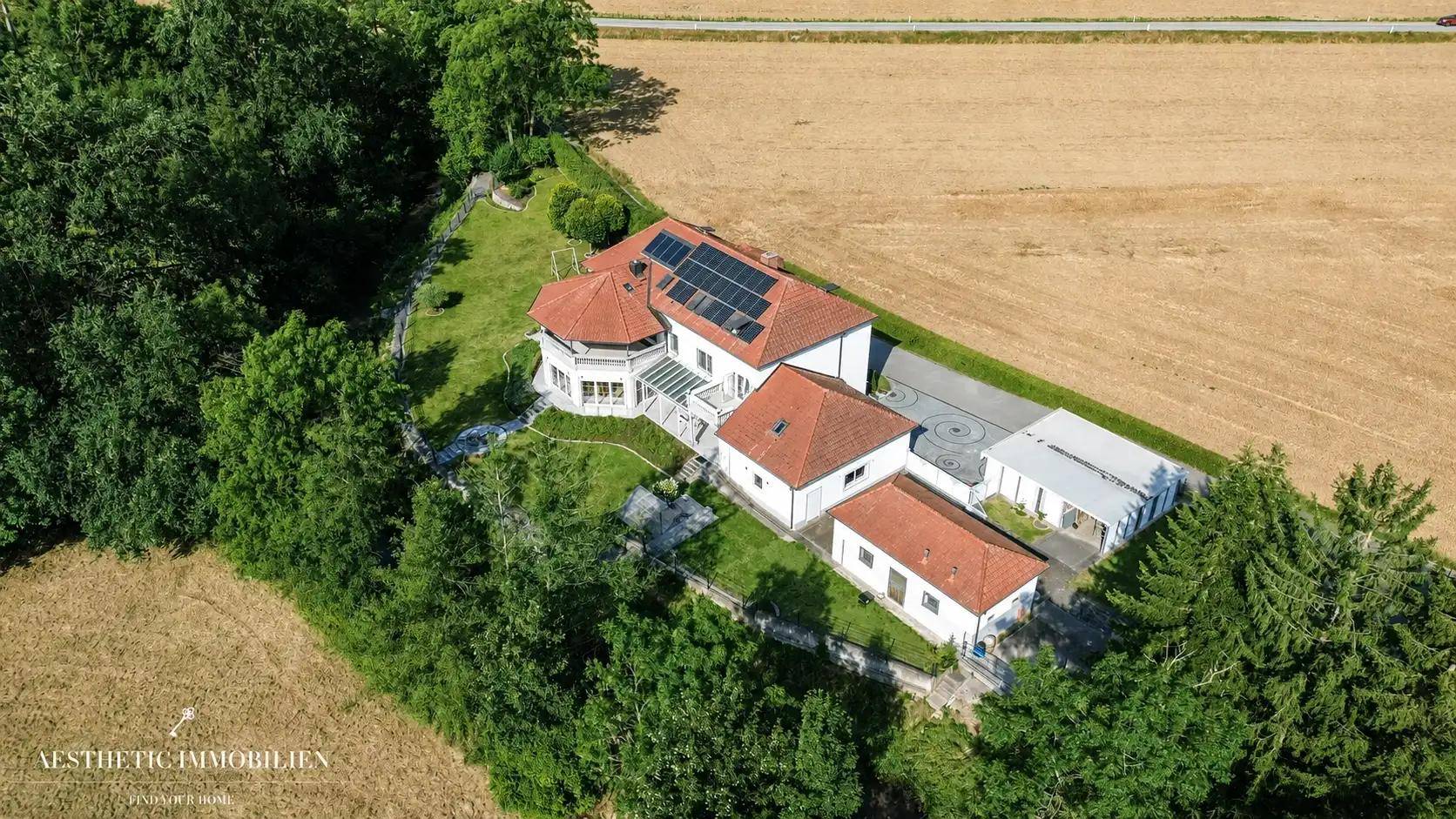 Vogelperspektive des Anwesens mit Solaranlage auf dem Dach und umgebender Natur.
