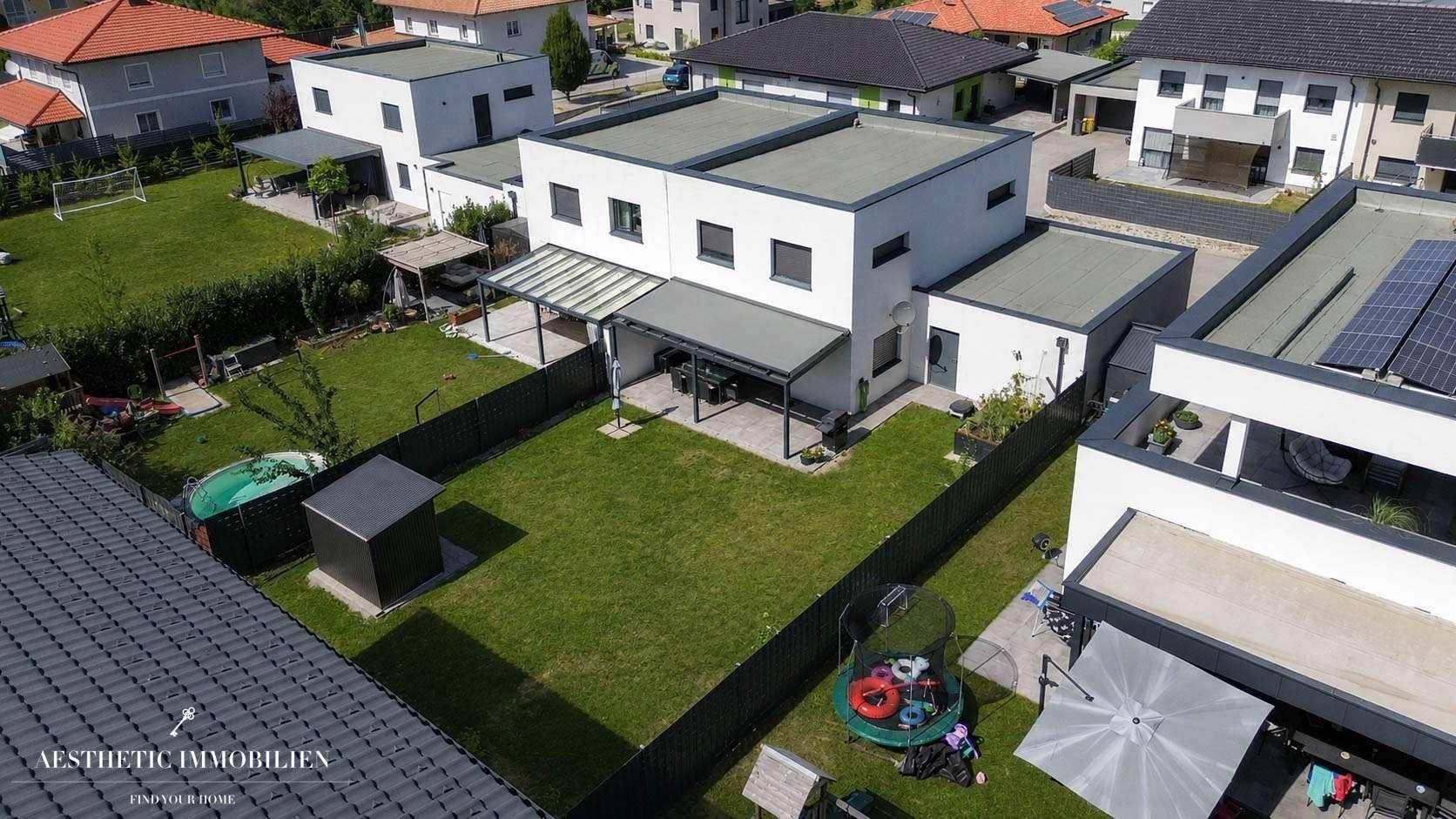 Luftaufnahme des Hauses mit Garten, Terrasse und Blick auf die umliegende Bebauung.