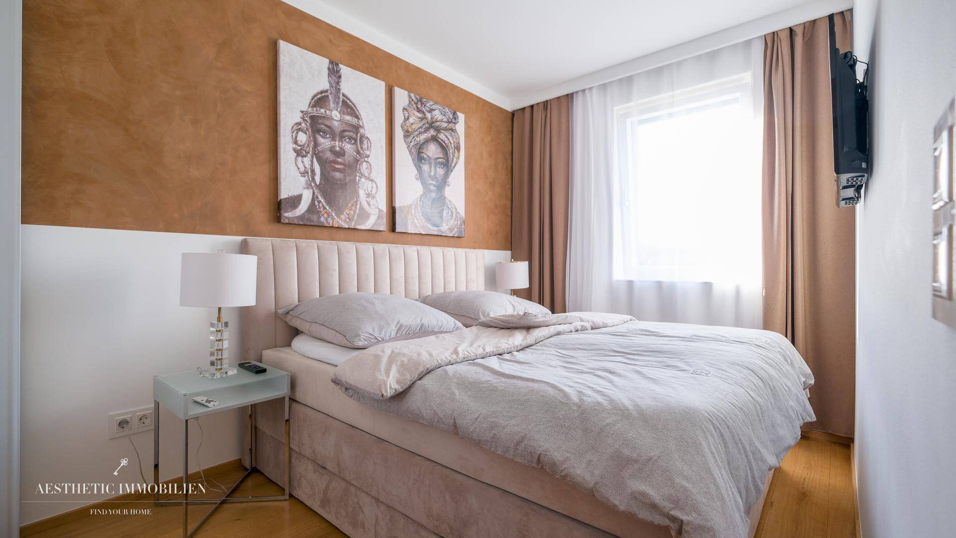 Komfortables Schlafzimmer mit Doppelbett, Holzboden und warmer Wandfarbe.