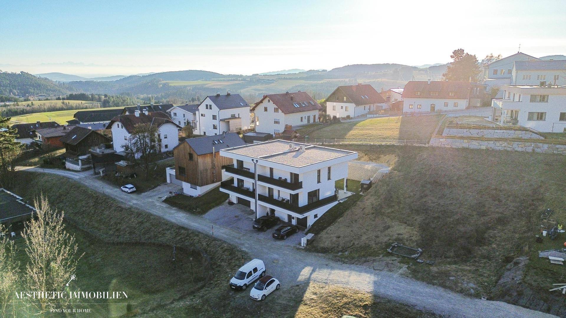 Luftaufnahme eines modernen Wohngebäudes in ländlicher Umgebung mit viel Grün.