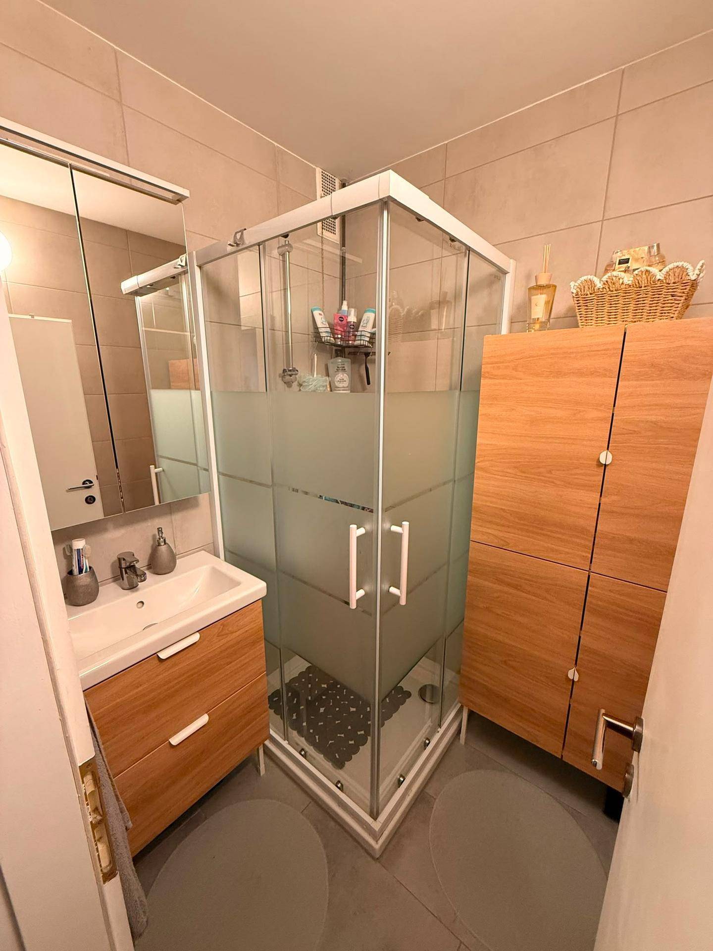 Modernes Badezimmer mit Eckdusche, Einzelwaschbecken und Holzunterschränken.