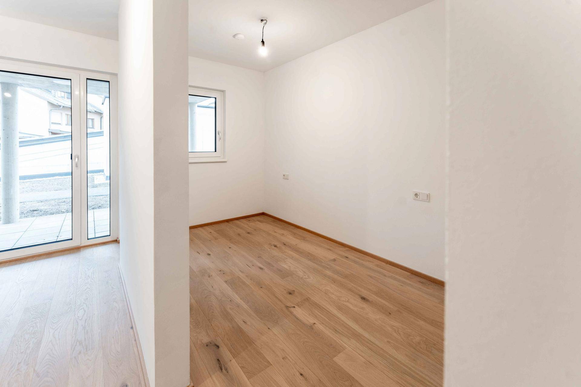 Helles Zimmer mit Parkettboden und Fenster, ideal als Schlaf- oder Arbeitszimmer.