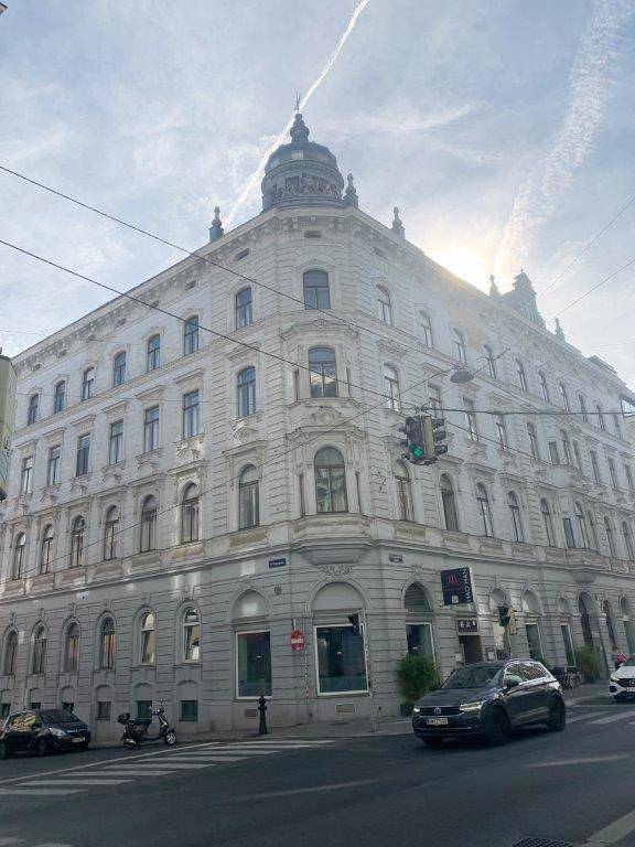 Historisches Eckgebäude mit prächtiger Architektur und Kuppel in urbaner Umgebung.